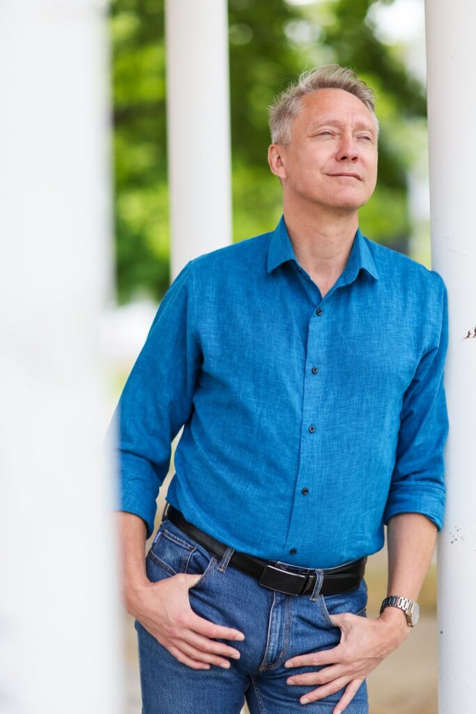 Holger Holland lehnt an einer weißen Säule